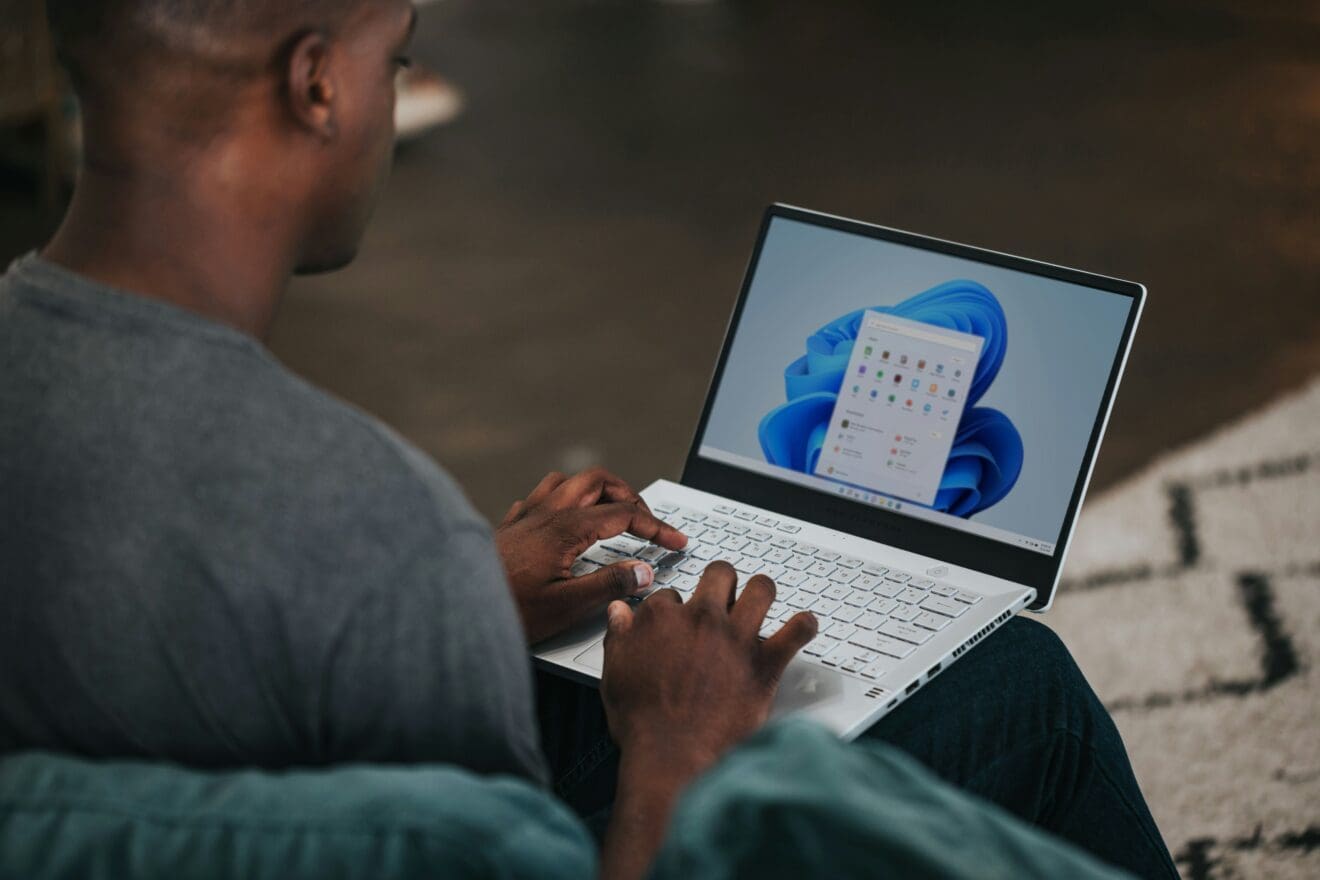 Zdjęcie pokazuje człowieka pracującego na laptopie